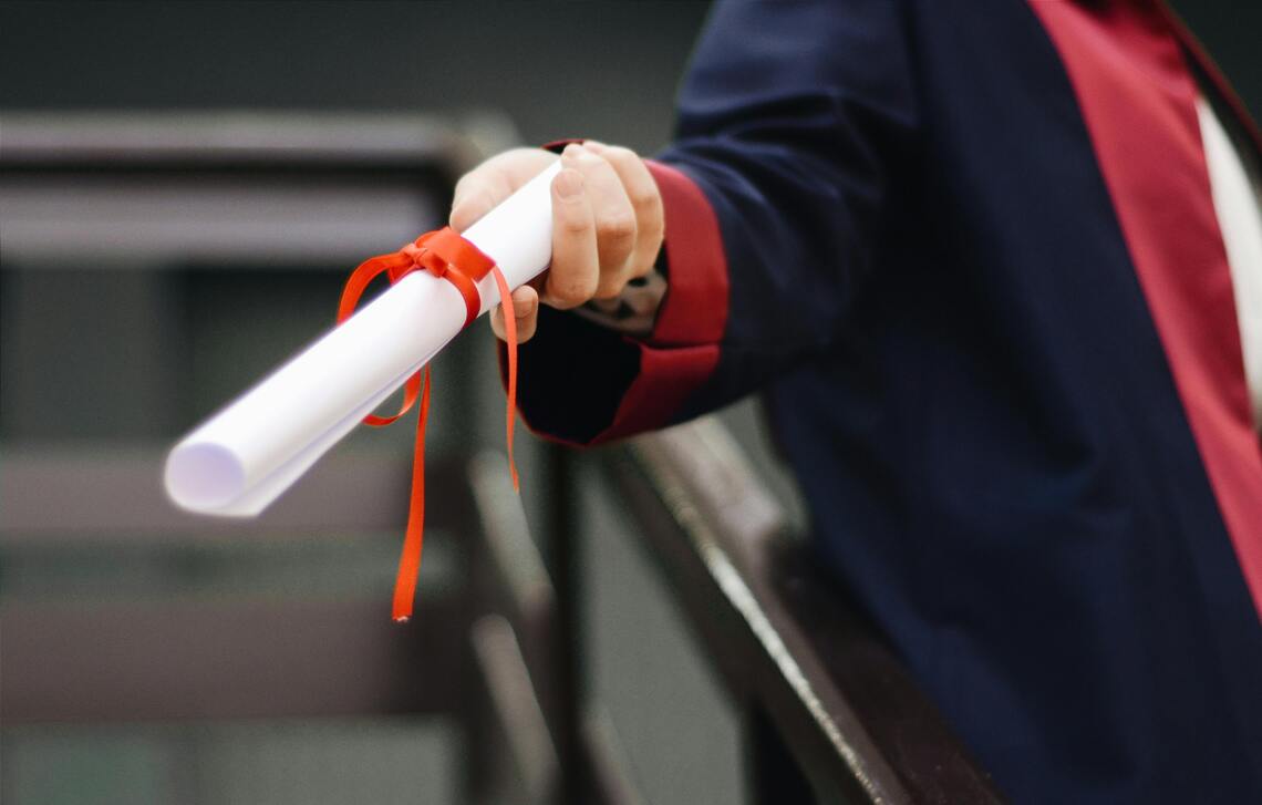 Person holding a white scroll.